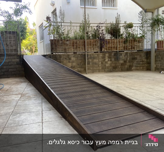 רמפה מעץ בגינה עם צמחים מסביב
